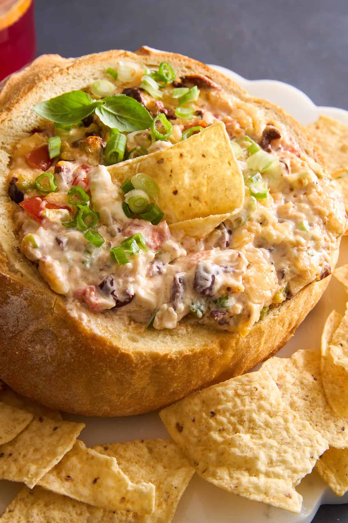 A sourdough bread bowl cheese dip bowl with a tortilla chip sticking out.