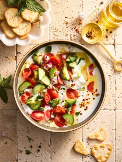 A bowl of cucumber and tomatoes with cottage cheese.