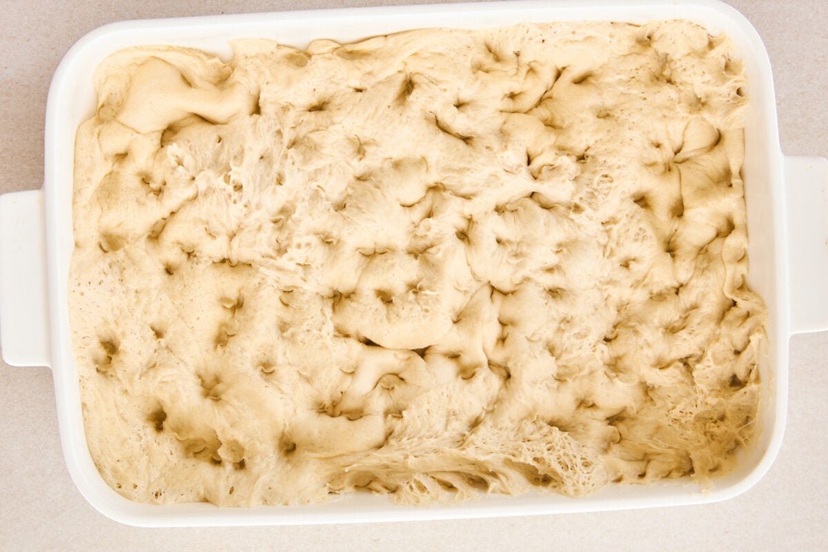 Dimples pressed into raw dough in a baking dish.