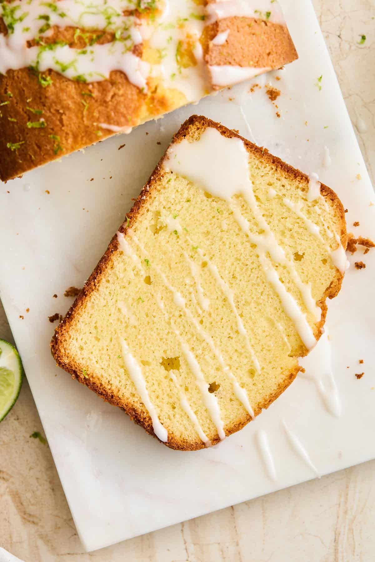 A slice of lime bread topped with lime glaze. 