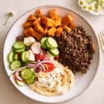 A ground beef bowl with roasted sweet potatoes, fresh veggies, and cottage cheese.