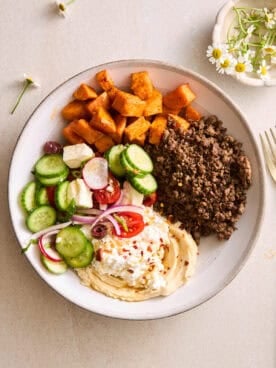 A ground beef bowl with roasted sweet potatoes, fresh veggies, and cottage cheese.