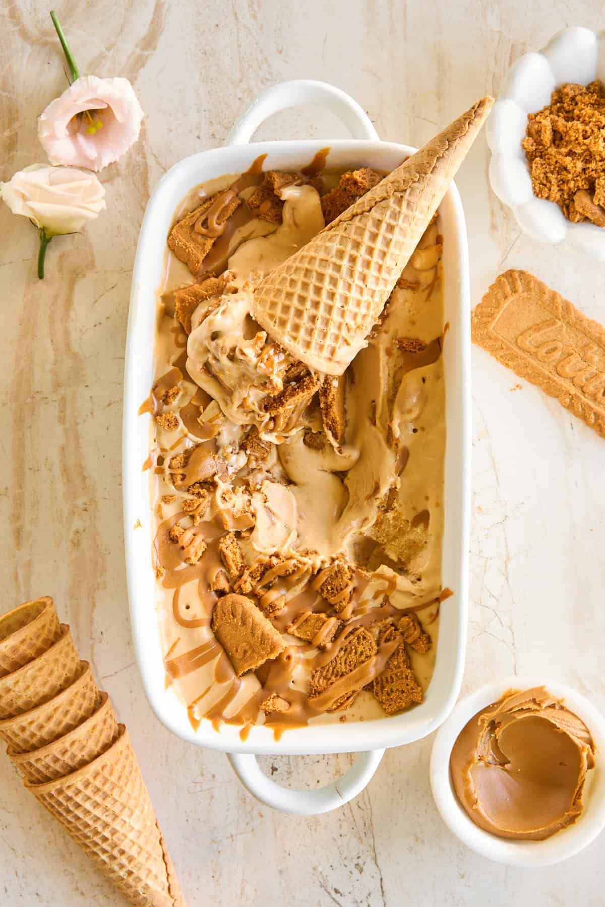 A dish of no-churn Biscoff ice cream with ice cream cones on top. 