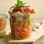 A Whiskey cucumber and tomato salad in a jar.