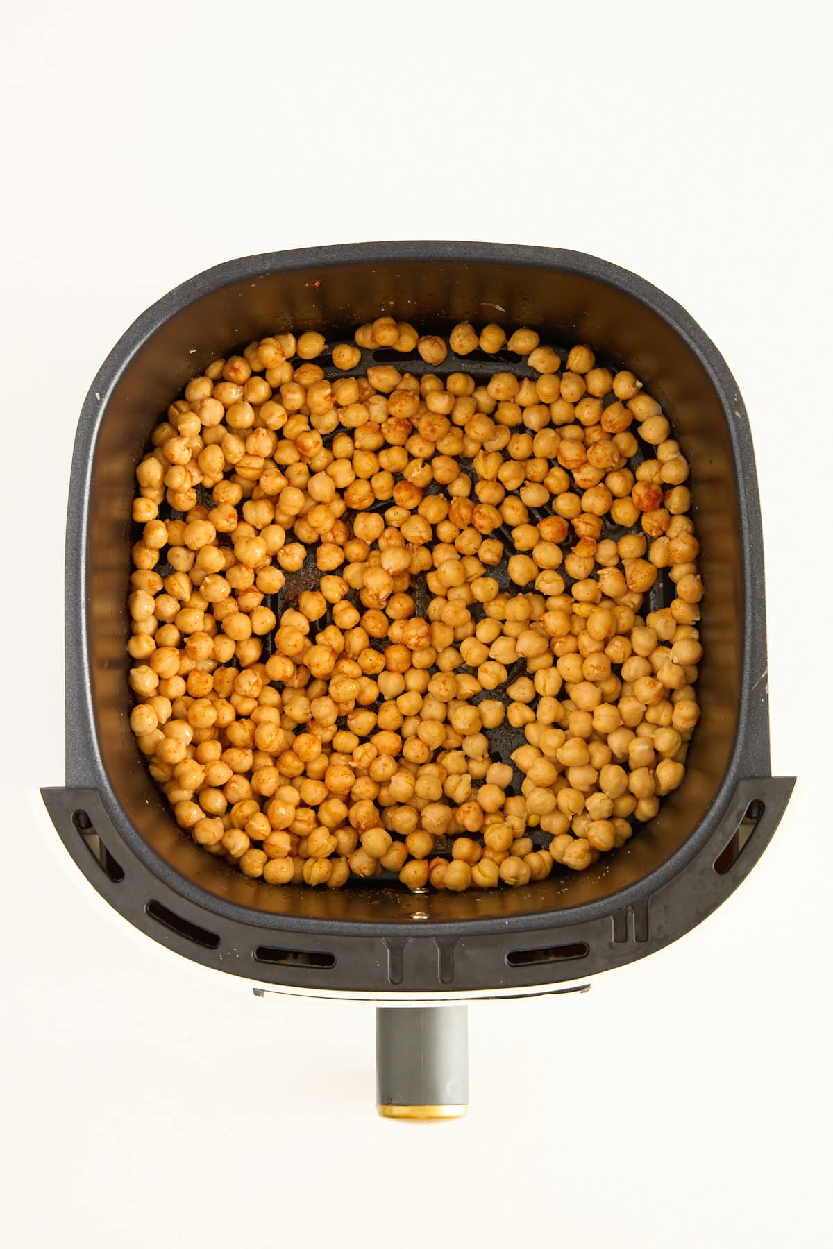 Uncooked chickpeas in an air fryer basket. 